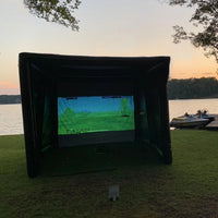 Tente de golf gonflable – tente noire au bord d'un lac, écran allumé à l'intérieur