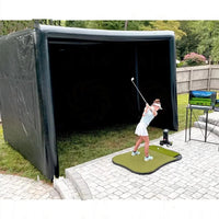 Boîtier de simulateur de golf gonflable – enceinte noire installée dans un jardin avec une golfeuse