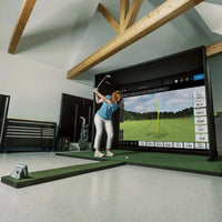 Cage de golf à cadre métallique – golfeuse face à l'écran dans une pièce mansardée