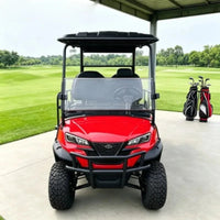 Voiturette de golf électrique surélevée 4 places – carrosserie rouge vue de face près de sacs de golf