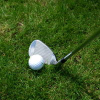 Série de fers de golf – fer posé derrière une balle sur l'herbe