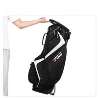 Sac de golf trépied 14 compartiments – main soulevant le sac noir et blanc par la poignée, sac sur son trépied