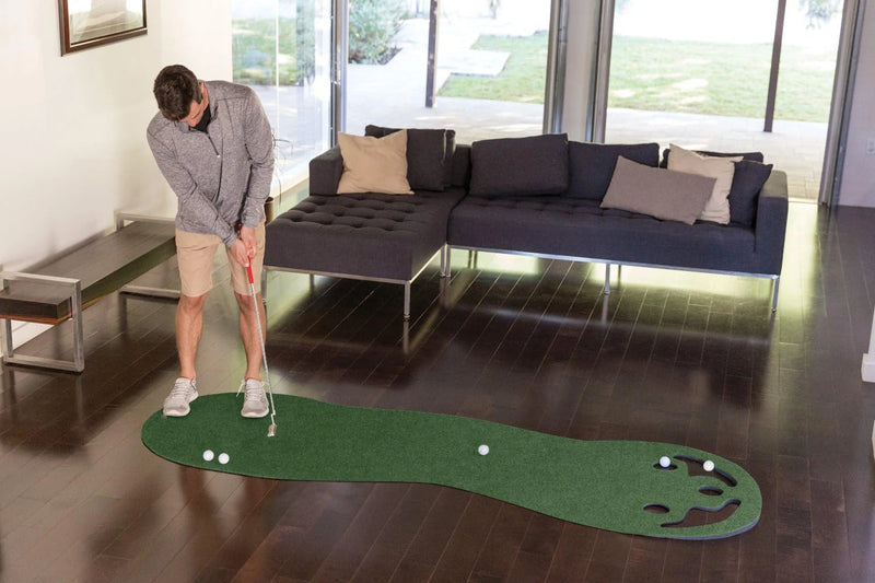 Putting green d'intérieur – golfeur au putting, tapis posé au sol d'une pièce