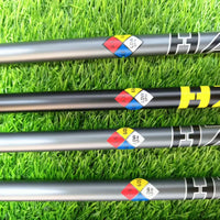 Manche de golf driver graphite fumé – manches posés sur du gazon avec leurs repères de dureté
