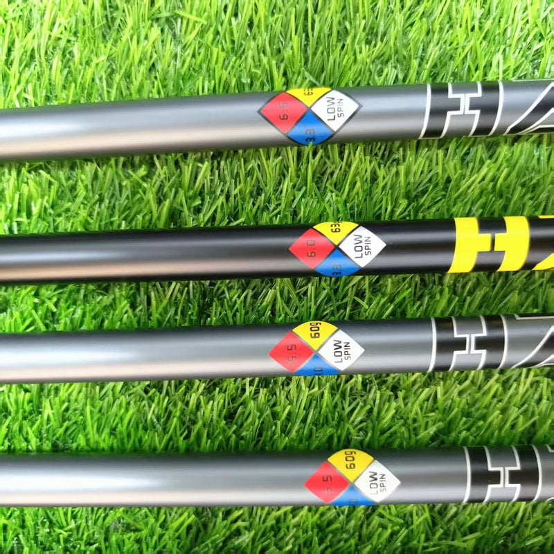 Manche de golf driver graphite fumé – manches posés sur du gazon avec leurs repères de dureté