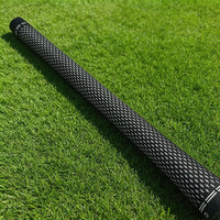 Grips de golf noir et blanc – un grip posé sur le gazon, vue d'ensemble