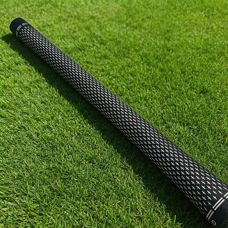 Grips de golf noir et blanc – un grip posé sur le gazon, vue d'ensemble