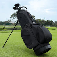 Sac de golf trépied 14 compartiments – sac noir debout sur son trépied sur un parcours, avec ses clubs