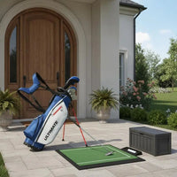Set de golf complet débutant – sac posé à l'entrée d'une maison avec un tapis de putting