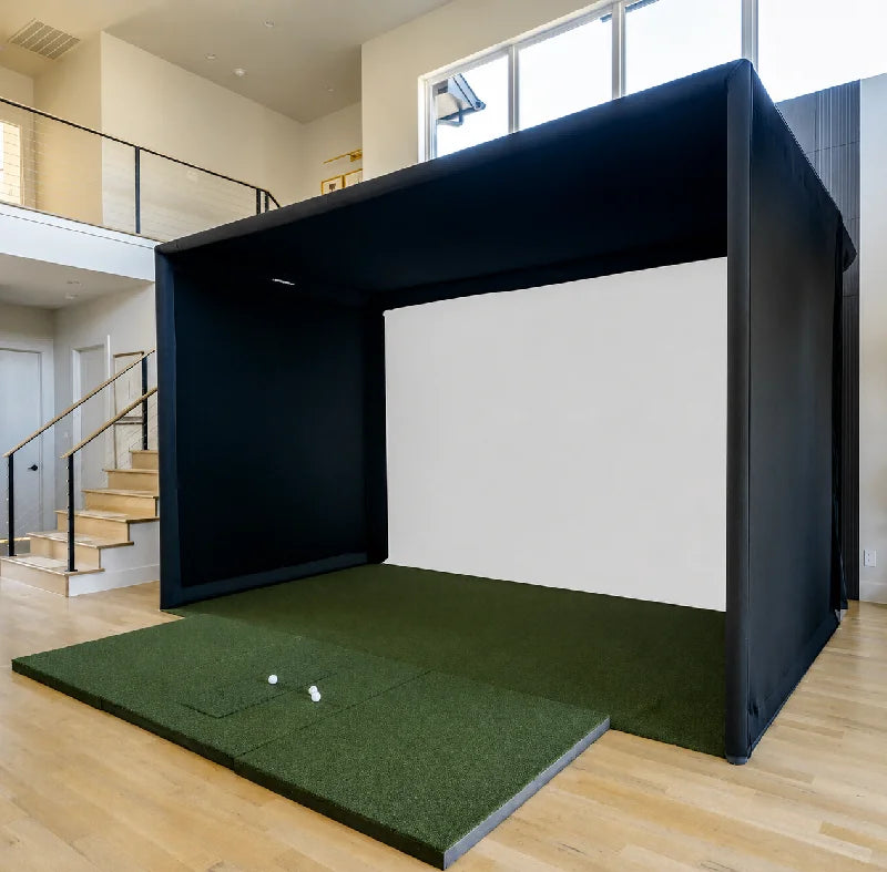 Cage de golf – enceinte noire installée dans une pièce avec écran blanc et tapis