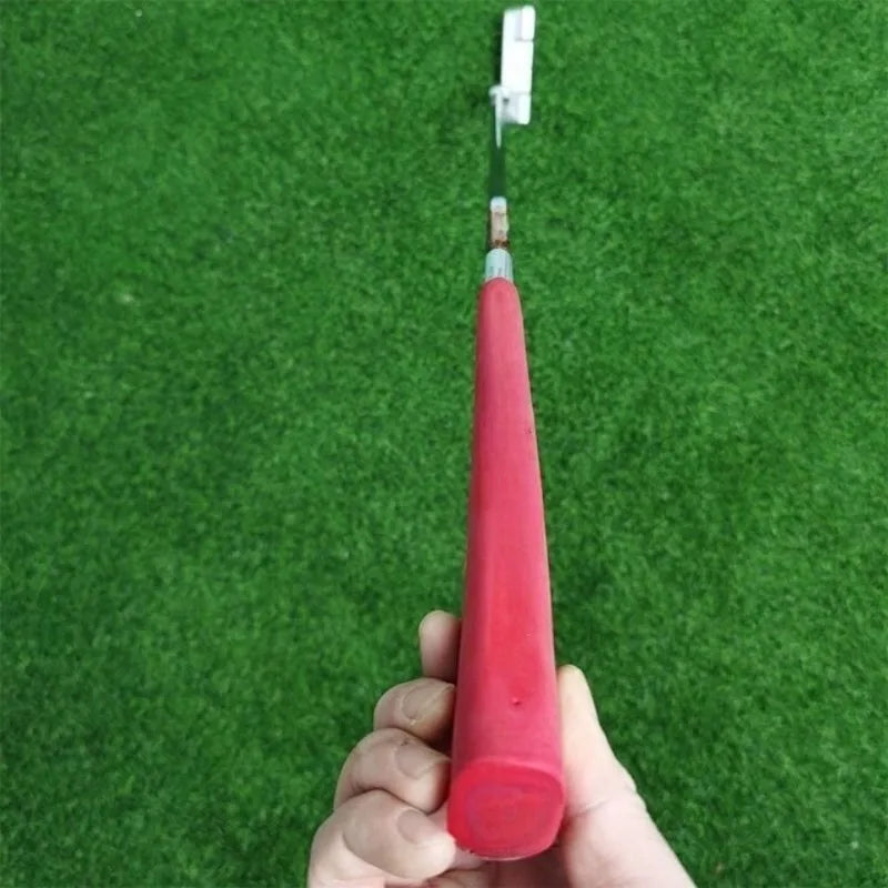 Putter lame argenté usiné – grip rouge tenu à la main avec le haut du manche