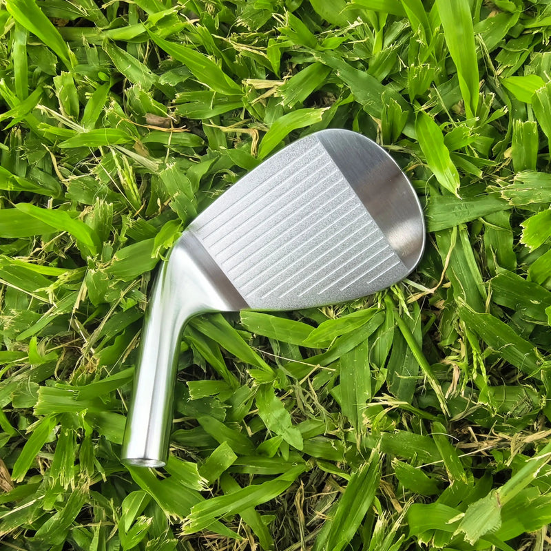 Tête de wedge de golf forgée – face rainurée posée dans l'herbe