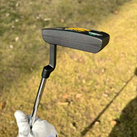 Putter maillet noir en D – autre tête vue de côté tenue par un golfeur