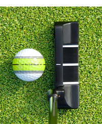 Putter lame noir – tête posée derrière une balle de putting, vue de dessus avec les traits d'alignement