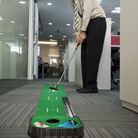 Tapis de putting intérieur 2,7 m – golfeur en costume au putting sur le tapis dans un couloir de bureau