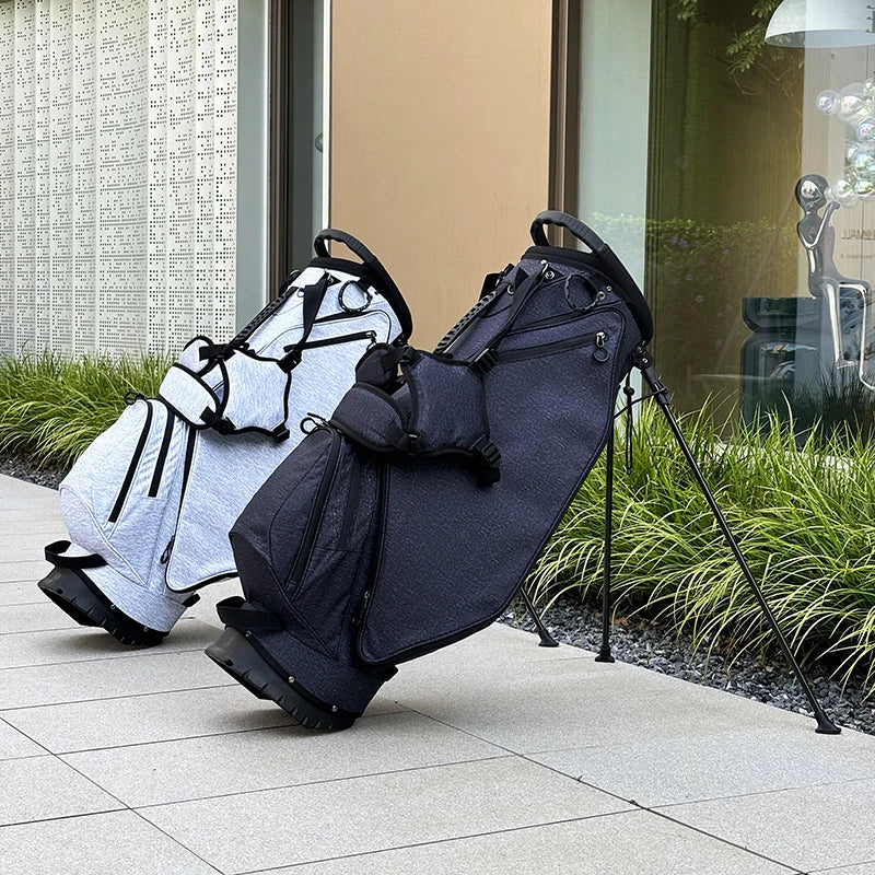Sac de golf trépied ultraléger – deux sacs gris clair et bleu marine sur leur trépied devant un bâtiment