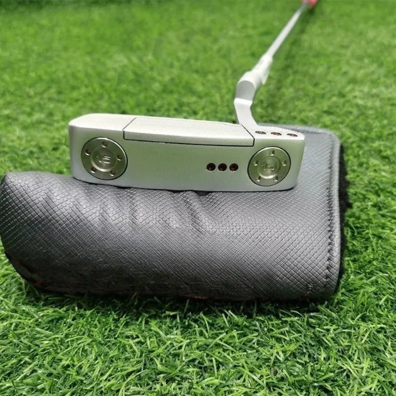 Putter lame argenté usiné – tête vue de face posée sur un couvre-putter gris